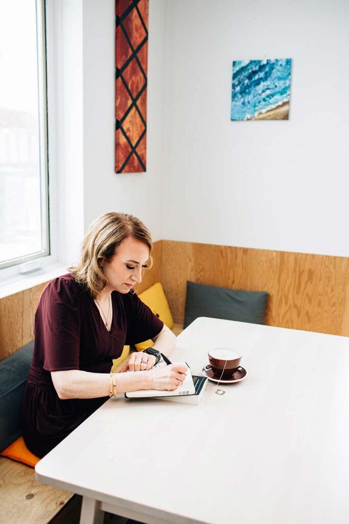 Catherine taking notes while drinking tea